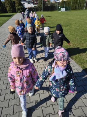 dzieci sprzątają teren wokół przedszkola